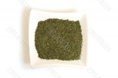 dried dill in square white bowl isolated