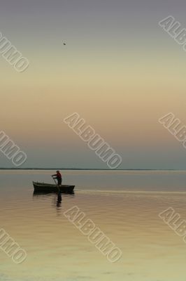 Lonely boat on silent water. sunset