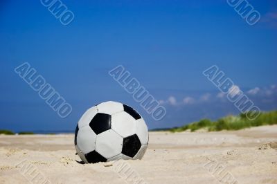 Soccer ball on sandy beach