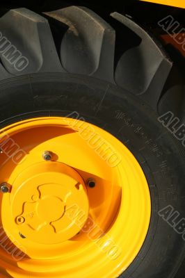 New wheel of a yellow building tractor
