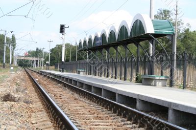 Railway station, rails, wires and a traffic light Railway station, rails, wires and a traffic light