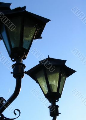 Old street lamp on blue sky background