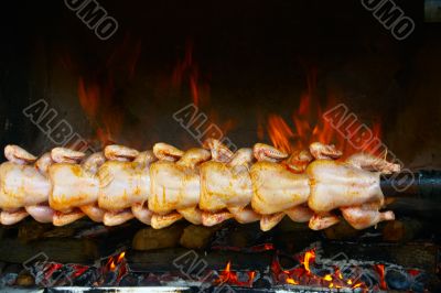 Broiling chicken on spit