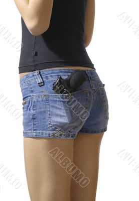 Girl in blue jeans short black pistol