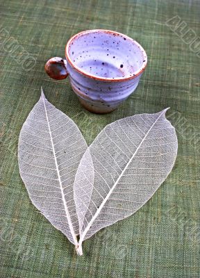 Pottery cup and leaves