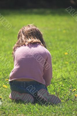 a little girl playing in grass