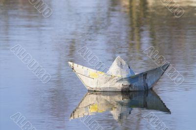 a paper boat floating in a lake