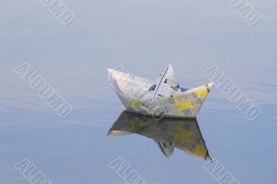 a paper boat floating in a lake