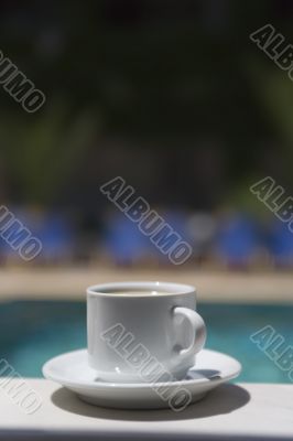 cup coffee on background of the pool