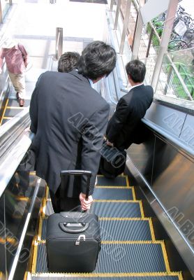 Businessmen on moving staircase