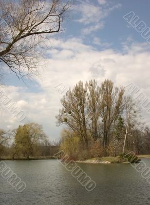 Island on pond in big park. Fall