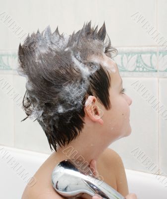 Boy with hair in soap in bathtub