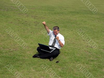 Happy man with computer in the field