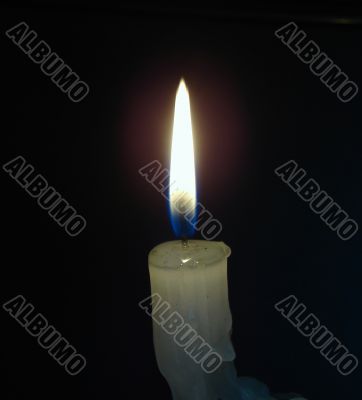 Alone candle flame upon black background