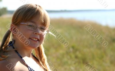 A merry girl is spectacled near a sea