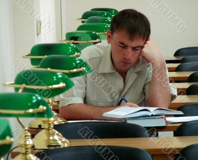 Student reading book in public library