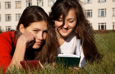 Girls reading the books on the lawn