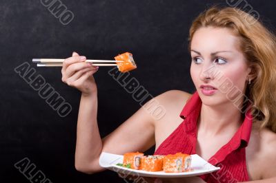 Beautiful girl looking of sushi