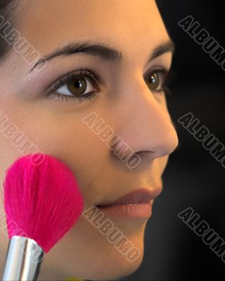 Young beautiful woman applying male-up