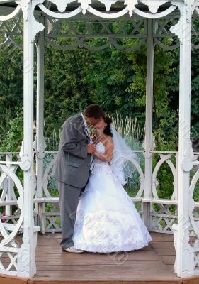 Wedding Pair Kissing in White Summer House