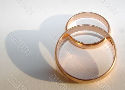 Two wedding gold rings on white background