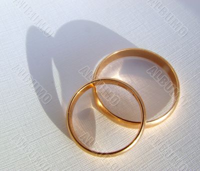 Two wedding gold rings on white background