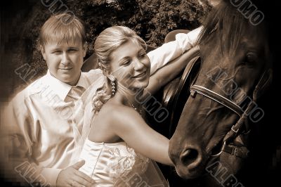 Groom and bride holding a brown horse Groom and bride holding a brown horse