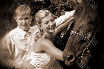 Groom and bride holding a brown horse