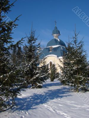 Winter snowy landscape with fur-trees and church