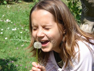 The girl playing with a dandelion