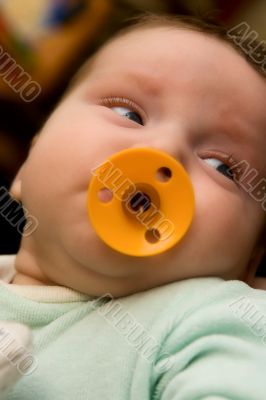 The small baby with a dummy in a mouth