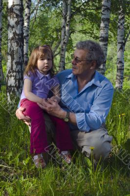 Grandfather and granddaughter in the woods