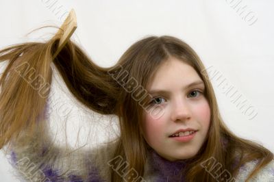 Portrait of the young girl combing hair