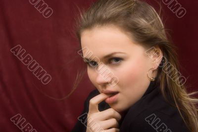 Portrait of the girl with a finger in a mouth