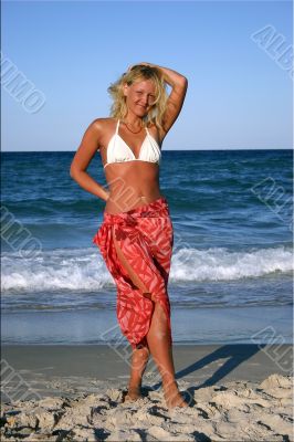 beautiful blonde in red skirt on the beach