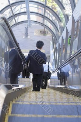 Businessman on moving staircase