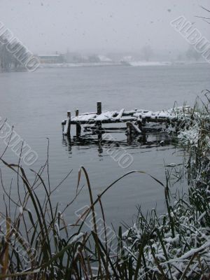 First season snowfall on riverside water