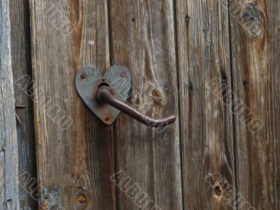 Aged door handle on wooden door