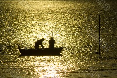 Two fisherman in water with back light