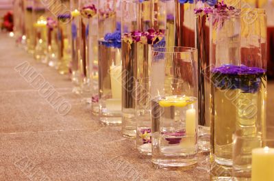 Row of different vases with flowers and candles