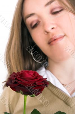 beautiful girl looking at rose - focus on rose