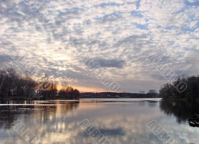 Colorful sunset upon riverside reflected in water