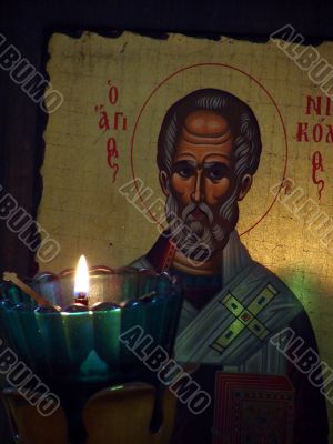 The slavic St Nicolay Icon and burning candle The slavic St Nicolay Icon and burning candle