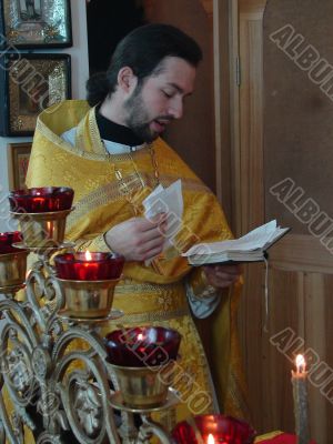 orthodox priest praying with Gospel in hands