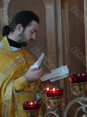 orthodox priest praying with Gospel in hands