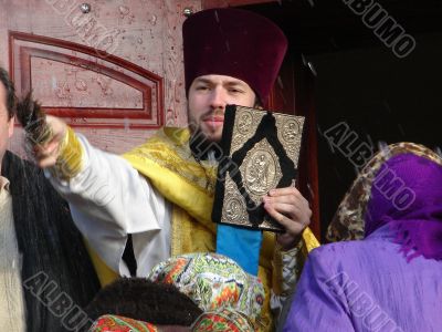 Russian Orthodox priest making water baptizm