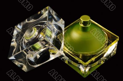 Opened perfume bottle over black