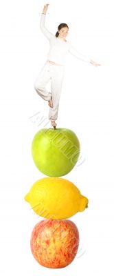 Casual girl balancing on fruits - balanced diet