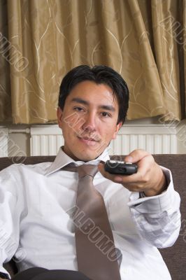 business man on a sofa with remote control