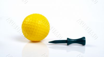 Yellow golfball and green tee with reflecting